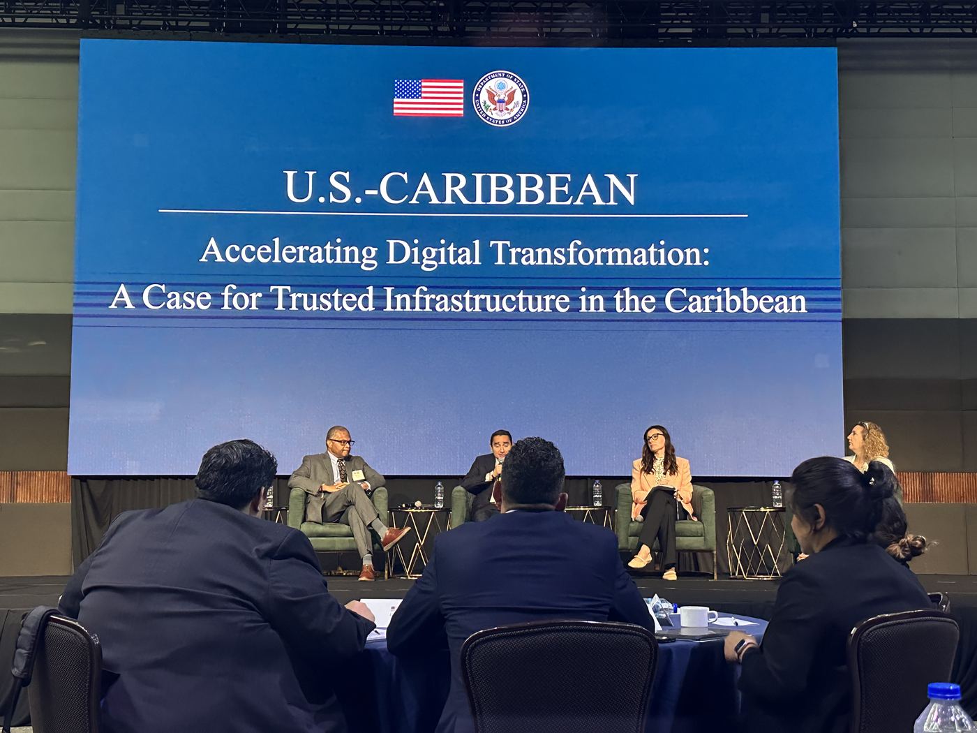 Panellists on stage beneath a screen reading Accelerating Digital Transformation