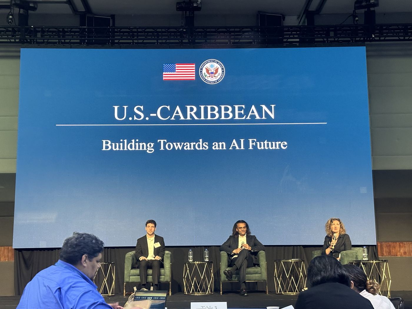 Three panellists on stage under a title slide reading Building Towards an AI Future