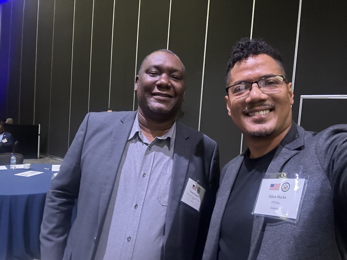 Two delegates in the conference hall wearing name badges